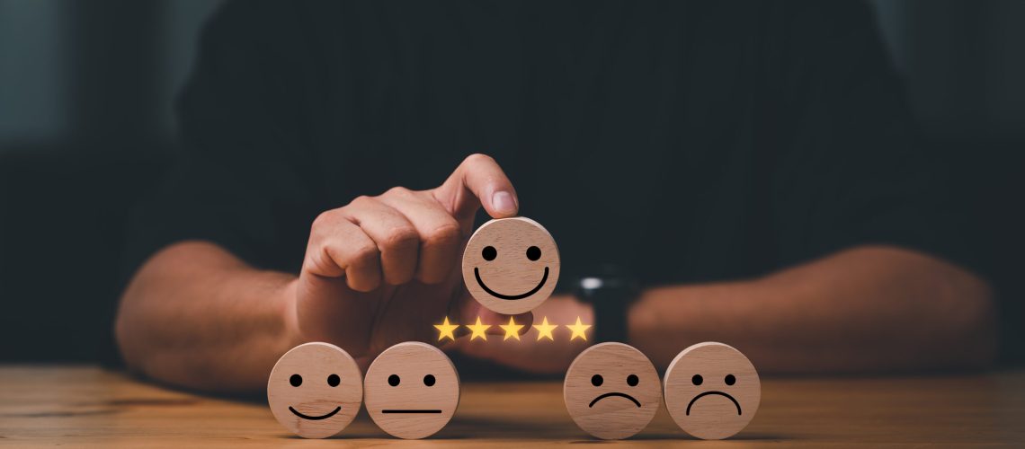 customer services best excellent business rating experience. Satisfaction survey concept. Hand of a businessman chooses a smile face on wood block cube. 5 Star Satisfaction.